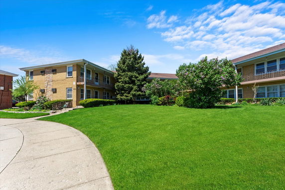 Front view of a two-story residential building with a well-maintained lawn.