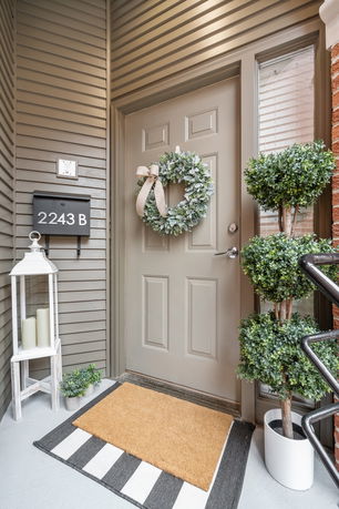 Front door of a house with a wreath and a doormat