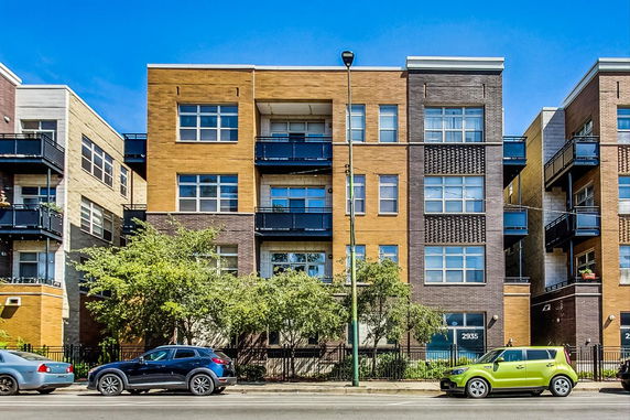 Front view of a modern multi-story apartment building with balconies.