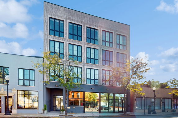 Front view of a multi-story building with large windows.