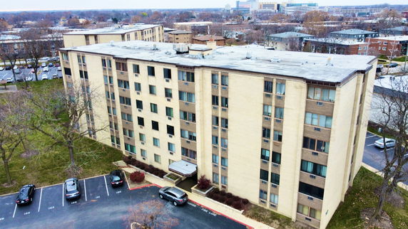Front view of a multi-story apartment building with large windows.
