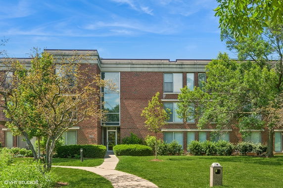 Front view of a multi-story brick building with large windows and a central entrance.