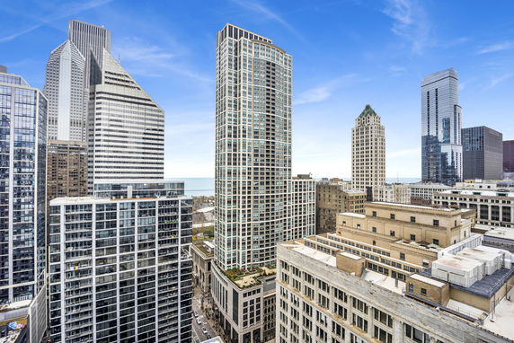 Panoramic view of a cityscape with multiple skyscrapers under a clear blue sky.