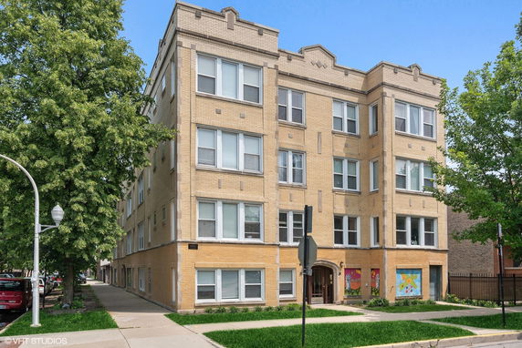Front view of a four-story apartment building with a brick exterior.