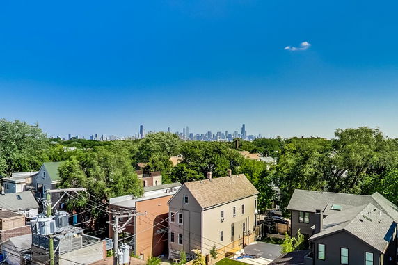 Panoramic view overlooking a suburban area with distant city skyline.