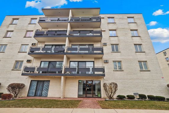 Front view of a multi-story apartment building with balconies.