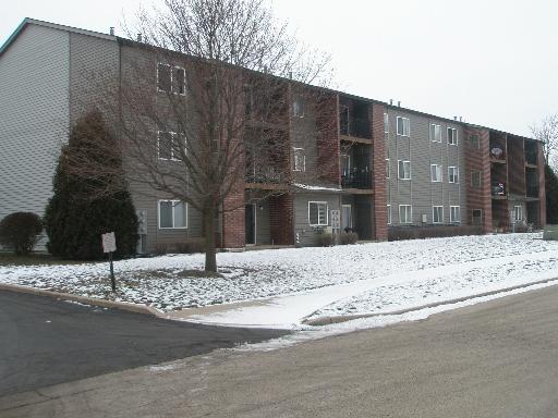 Front view of a three-story apartment building with brick and siding exterior.