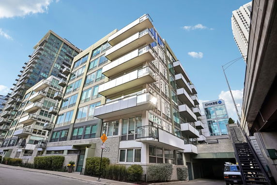 Front view of a modern multi-story apartment building with balconies.