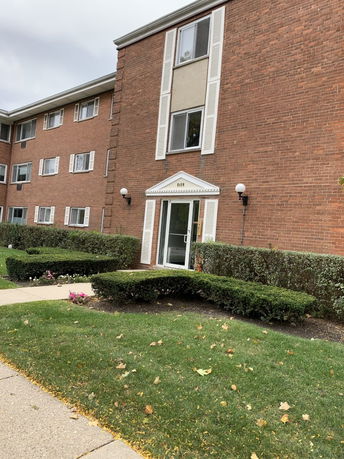 Front view of a multi-story brick building with entrance.