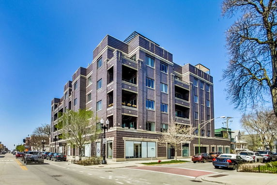 Front view of a multi-story apartment building with brick exterior.