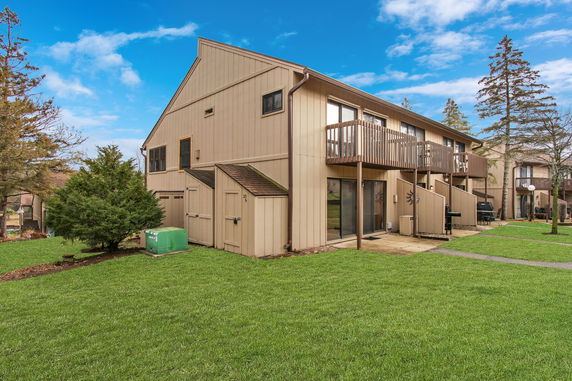 Side view of a two-story building with balconies and storage areas.