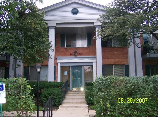 Front view of a two-story brick apartment building with columns.