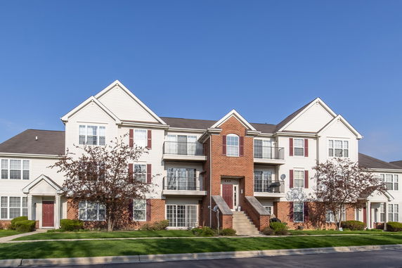 Front view of a multi-story residential building with a brick and siding exterior.