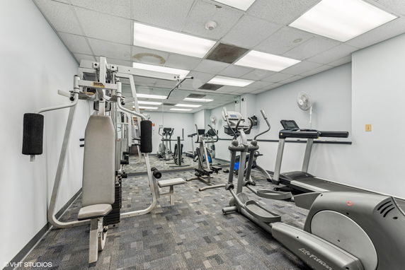 Indoor gym area with exercise equipment, including treadmills and elliptical machines.