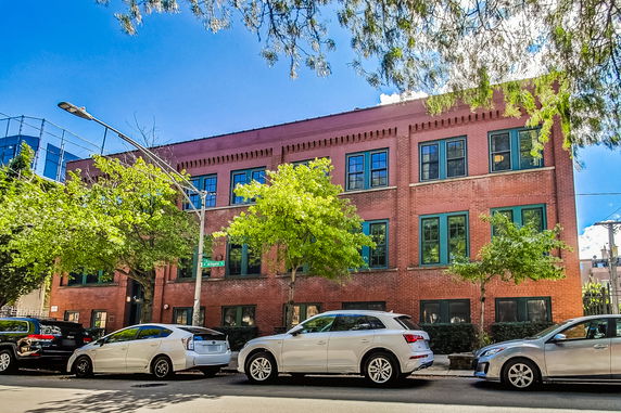 Front view of a three-story brick building with multiple windows.