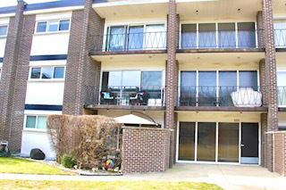 Front view of a multi-story apartment building with balconies.