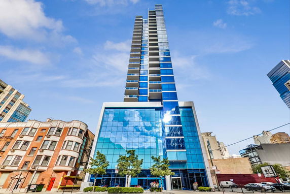 Front view of a modern high-rise building with blue glass facade.