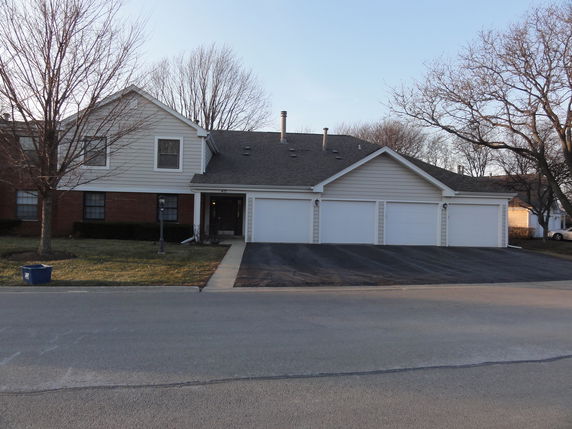 Front view of a two-story house with three garage doors.