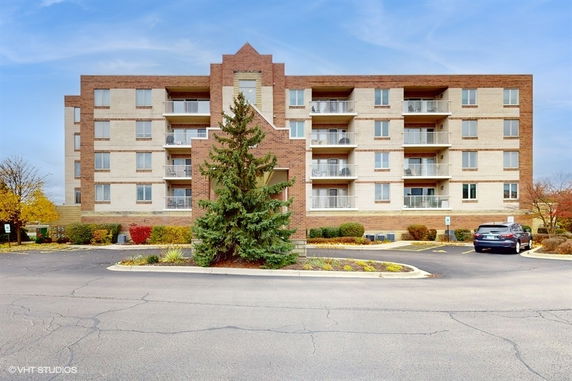 Front view of a four-story apartment building with balconies.
