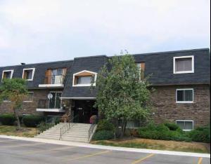 Front view of a multi-story building with a sloped roof.