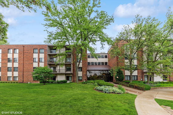 Front view of a multi-story building with balconies and brick facade.