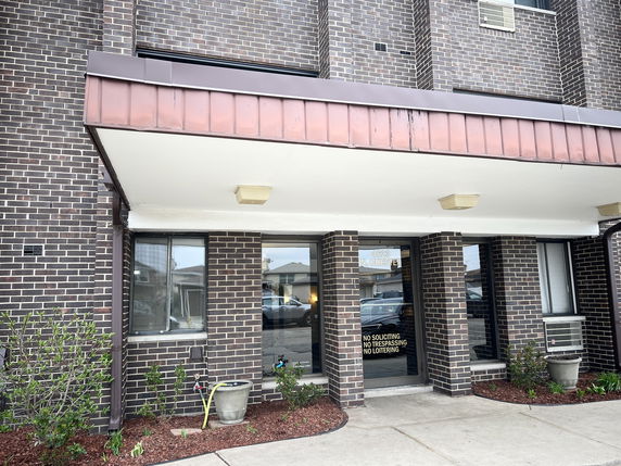 Front view of a brick building with a covered entrance.