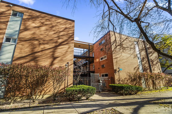 Front view of a multi-story brick building with an open staircase.