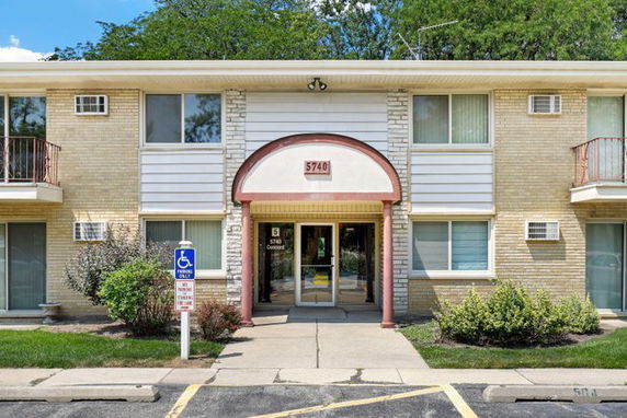 Front view of a two-story building with a central entrance and balconies.