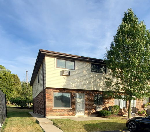 Front view of a two-story house with a brick and siding exterior.