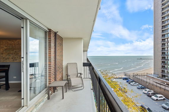 Balcony view of the ocean and surrounding buildings.