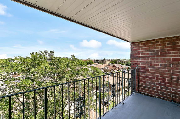 View from a balcony overlooking residential buildings and trees.
