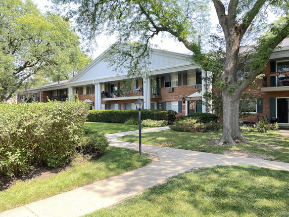Front view of a two-story building with balconies and columns.
