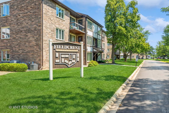 Front view of a multi-story condominium building with brick exterior and balconies.
