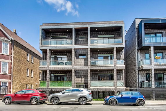 Front view of a modern multi-story residential building with balconies.
