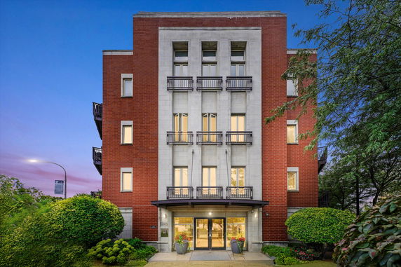 Front view of a multi-story brick building with large windows and balconies.