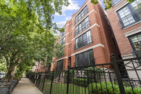 Front view of a multi-story brick building with black-framed windows.