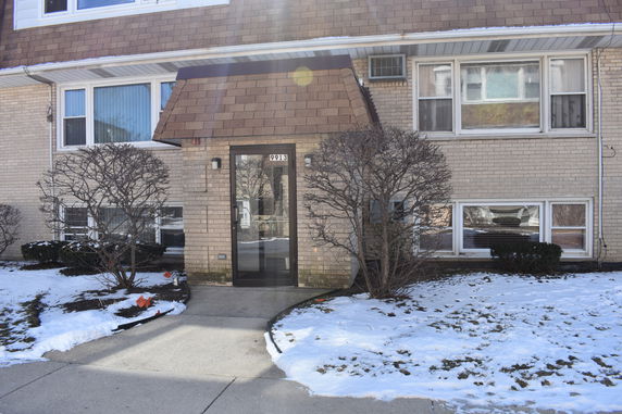 Front view of a house with brick exterior and an entrance walkway.