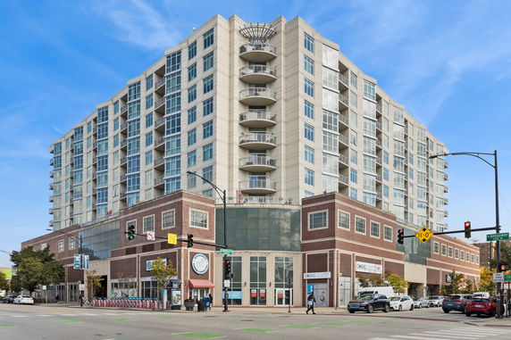 Front view of a multi-story building with retail space at the ground level and residential units above.