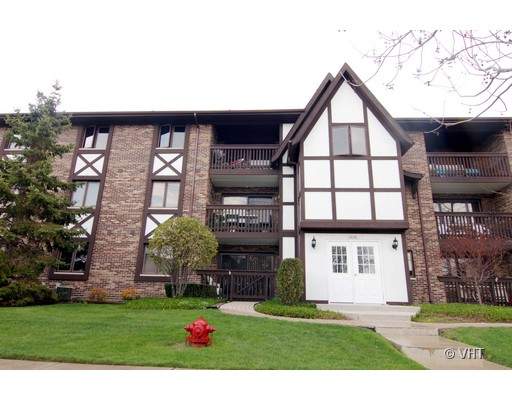 Front view of a multi-story apartment building with a Tudor-style facade.