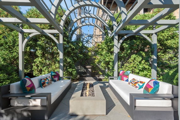 Outdoor seating area with modern couches under a pergola.
