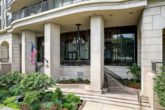 Front view of a multi-story building with large columns and glass windows.
