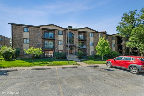 Front view of a multi-story brick apartment building.