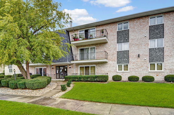 Front view of a three-story apartment building with balconies.