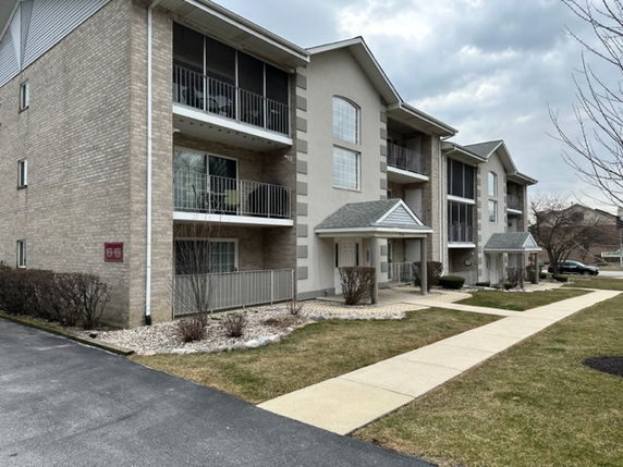 Front view of a multi-story apartment building with balconies.