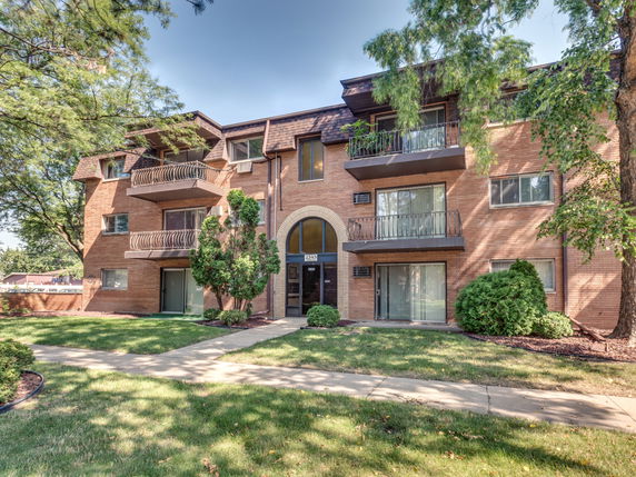 Front view of a three-story residential building with balconies.