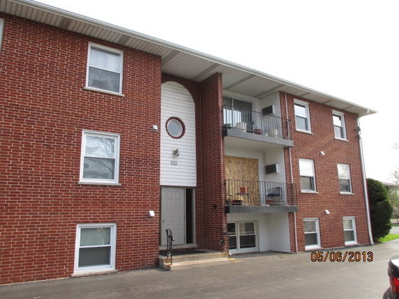 Front view of a three-story brick apartment building.