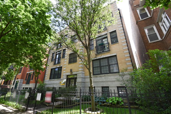 Front view of a multi-story apartment building with brick facade.