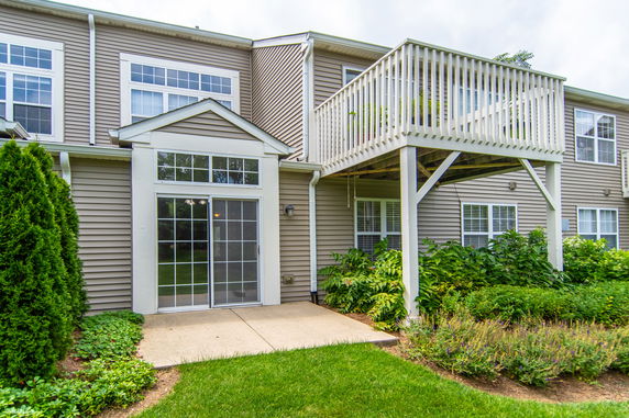 Front view of a house with a balcony and sliding doors.