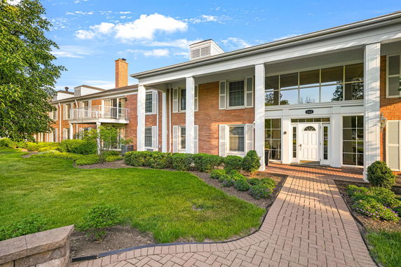 Front view of a two-story house with brick exterior and white columns.