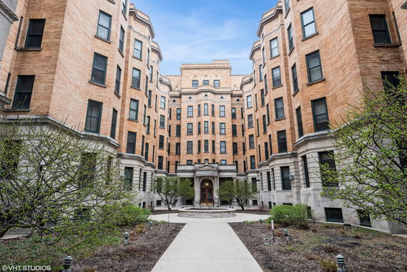 Front view of a multi-story brick building with a central courtyard.
